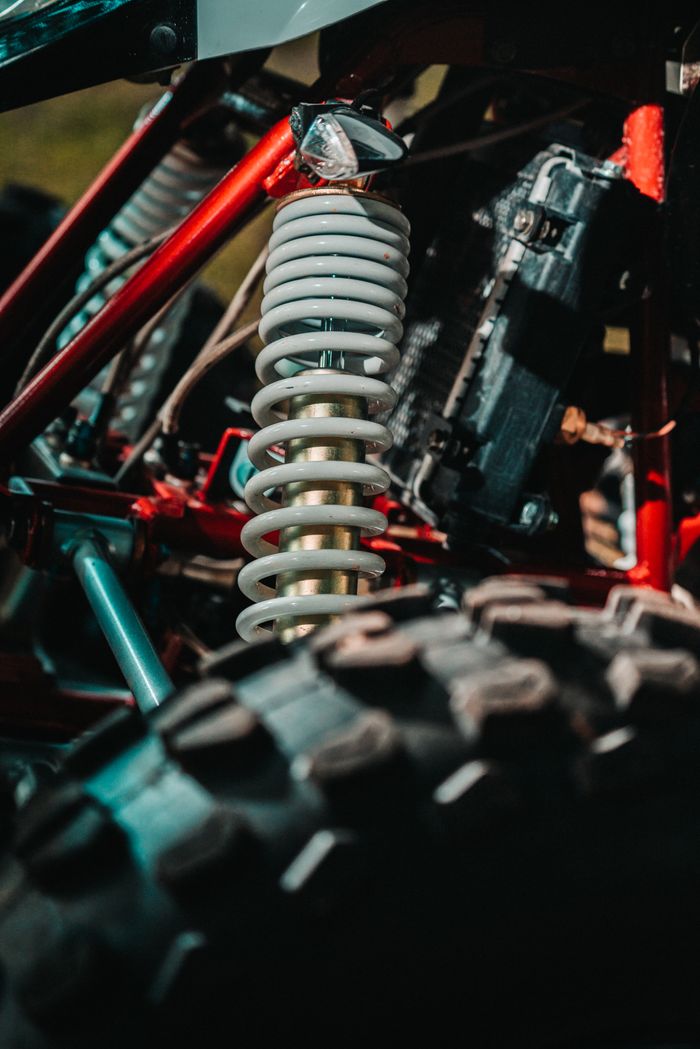 Detailed view of an ATV's coil spring suspension highlighting mechanical design and rugged build.